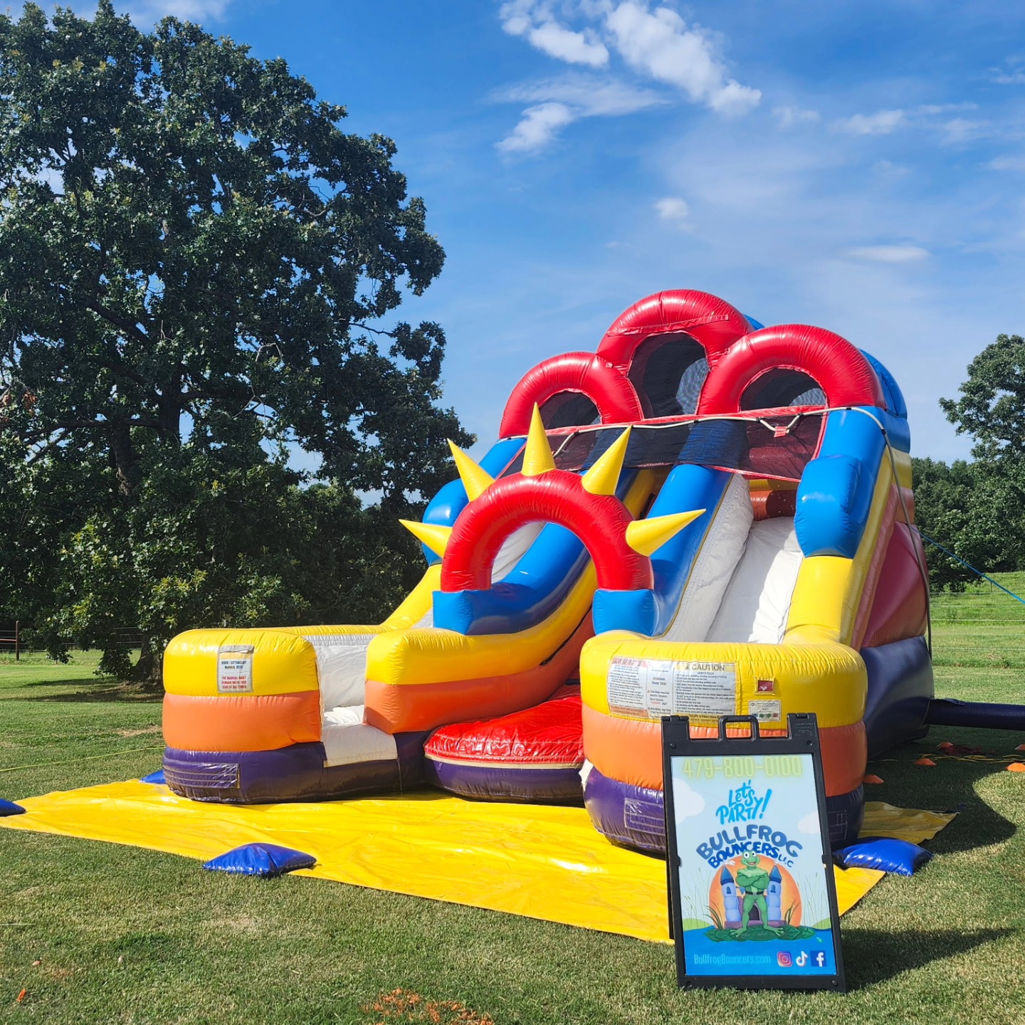 Colorful combo bounce house and slide rental setup at park